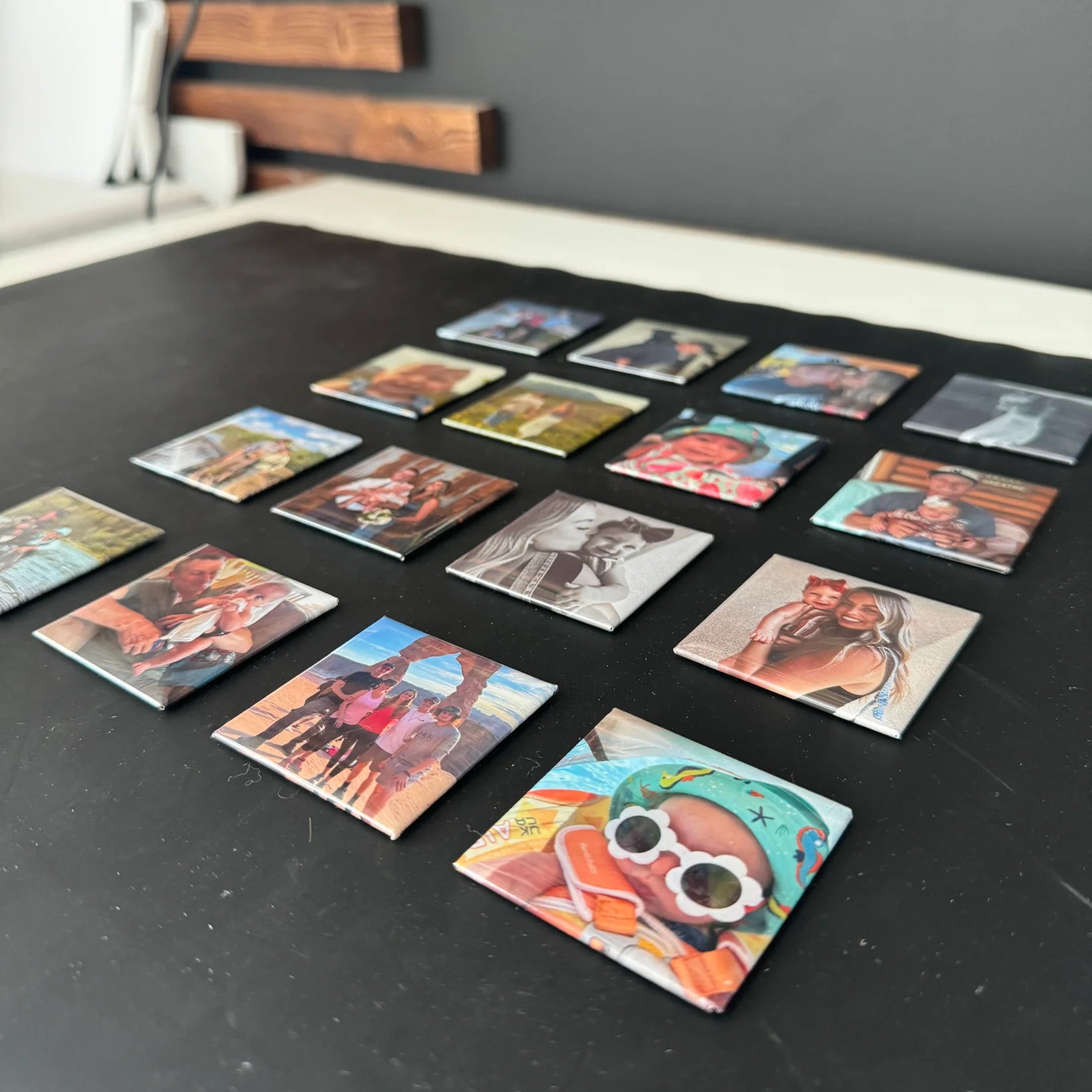 Collection of small square tiles with various designs on a dark surface.